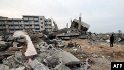 Palestinos revisan los escombros cerca de una escuela de la ONU donde desplazados se refugiaron después de que un ataque israelí golpeara una vivienda cercana, en Rafah, en el sur de la Franja de Gaza, el 21 de diciembre de 2023.