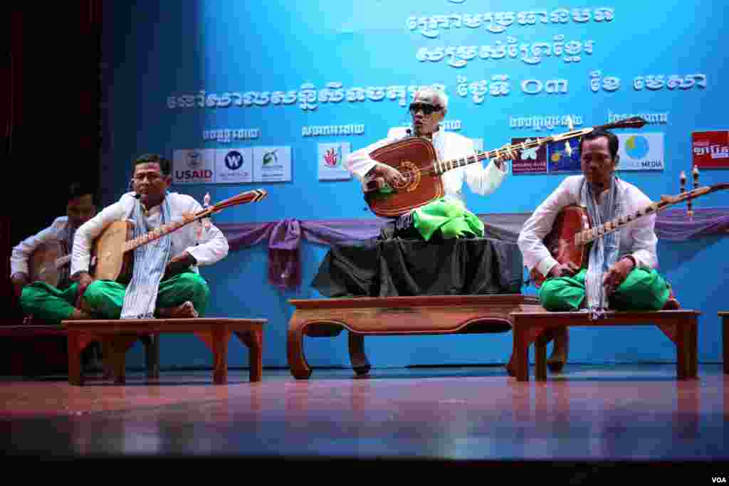 ព្រឹទ្ធាចារ្យចាប៉ីលោកតាគង់ ណៃ សម្ដែងអមដោយសិល្បៈករចាប៉ីក្មេងៗដទៃទៀតនៅក្នុងមហោស្រពចាប៉ីលើកទីមួយនៅសាលមហោស្រពចតុមុខនៃរាជធានីភ្នំពេញកាលពី ថ្ងៃអាទិត្យទី០៣មេសានេះ។(ឡេង ឡែន/VOA)