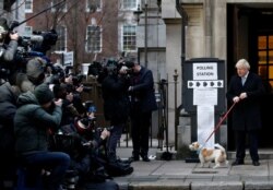 Britain's Prime Minister Boris Johnson arrives with his dog Dilyn at a polling station, at the Methodist Central Hall, to vote in the general election in London, Britain, Dec. 12, 2019.