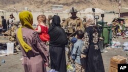 Pengungsi Afghanistan melewati pusat kendali evakuasi di Bandara Internasional Hamid Karzai di Kabul, Afghanistan, 28 Agustus 2021. (Foto: AP)