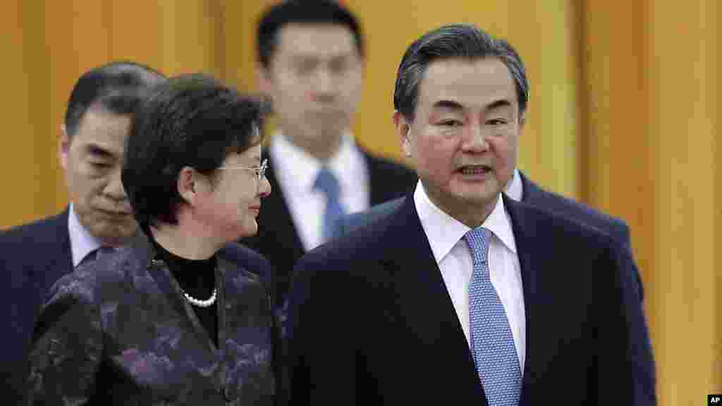 Le ministre chinois des Affaires étrangères Wang Yi (à droite) discute avec un délégué comme ils assistent à une cérémonie. La Chine a déclaré aux Etats-Unis qu'elle est contre les cyberattaques et s'oppose à toute nation d'où de telles attaques partent.