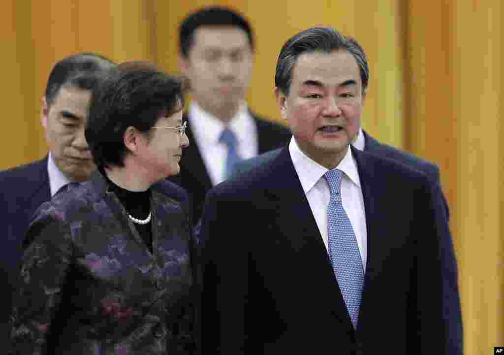 Menteri Luar Negeri China Wang Yi (kanan) berbincang dengan seorang delegasi saat menghadiri sebuah upacara. China mengatakan pada AS bahwa mereka menolak serangan dunia maya tapi tidak secara langsung mengutuk peretasan atas Sony Pictures (22/12). (AP/Andy Wong)