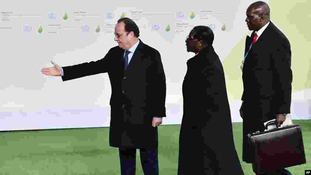 Le président Robert Mugabe du Zimbabwe est accueilli par son homologue français François Hollande, à gauche, à son arrivée à la COP21, au Bourget, 30 novembre 2015. 