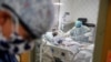 ARCHIVO - La médica residente Leslie Bottrell se encuentra afuera de una habitación en una Unidad de Cuidados Intensivos mientras una enfermera succiona los pulmones de un paciente con COVID-19, el 20 de abril de 2020, en el Hospital St. Joseph en Yonkers, Nueva York, EEUU.