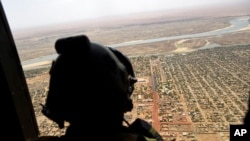 FILE - A French soldier stands inside a military helicopter during a visit by French President Emmanuel Macron to the troops of Operation Barkhane, May 19, 2017.