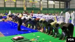 Anggota Syiah dari Sampang, Madura, Jawa Timur, shalat berjamaah di tempat pengungsian dalam gedung olahraga. (VOA/Petrus Riski)