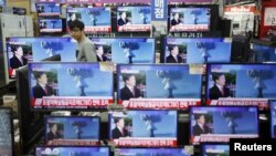 首尔的一名店员观看电视屏幕上有关朝鲜核试验的消息。（2016年1月6日）