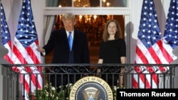 La nueva jueza de la Corte Suprema de EE. UU., Amy Coney Barrett posa con el presidente Donald Trump en la Casa Blanca tras ser juramentada al cargo. Octubre 26 de 2020.