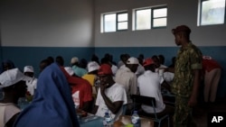 Atendidos por soldados y voluntarios de la Cruz Roja, los sobrevivientes del desafortunado viaje almuerzan en una escuela convertida en refugio, en la isla de Sal, Cabo Verde, el lunes 21 de agosto de 2023, una semana después de que su barco fuera encontrado perdido en el mar.