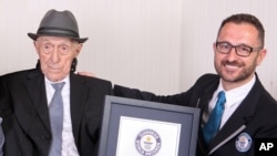 Marco Frigatti, dari Guinness World Records (kanan), menyerahkan penghargaan sebagai pria tertua di dunia kepada Israel Kristal di Haifa, Israel (11/3).