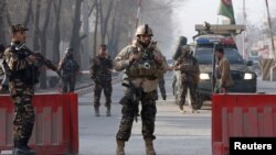 Afghan security forces keep watch at a check point close to a compound of Afghanistan's national intelligence agency in Kabul, Afghanistan, Dec. 25, 2017.