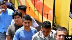 Salvadoreños deportados de los Estados Unidos se bajaron de un autobús, a su llegada al Centro de Atención a Migrantes en San Salvador el 22 de junio de 2018.