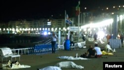 Des corps de victimes fauchés par un camion qui a foncé sur une foule en pleine une célébration de la fête nationale Jour de la Bastille, sont couchés a même la pelouse , à Nice, France, 14 juillet 2016.