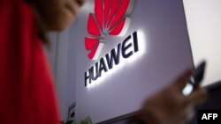 Sur cette photo, prise le 27 mai 2019, un logo Huawei est affiché dans un magasin de vente au détail à Beijing.