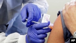 FILE - In this March 16, 2020, file photo, Neal Browning receives a shot in the first-stage safety study clinical trial of a potential vaccine for COVID-19, the disease caused by the new coronavirus, at the Kaiser Permanente Washington Health…