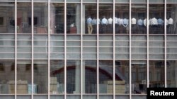 FILE - Staff stand in a meeting room at Lehman Brothers offices in the financial district of Canary Wharf in London, September 2008.