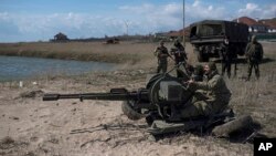 Ukrainian servicemen deploy a weapon at the beach of the Azov Sea in Shyrokyne, eastern Ukraine, April 15, 2015. 