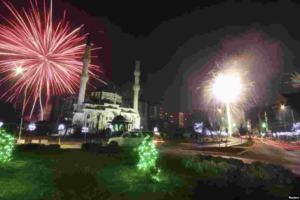Fireworks explode next to the Bayram Pasa Isa Beg mosque during New Year's celebrations in Mitrovica, Kosovo, Jan. 1, 2016.