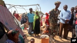 Un soldat somalien assure la sécurité alors que les Somaliens nouvellement déplacés se rassemblent dans un camp à la périphérie de Mogadiscio, en Somalie, le 28 mars 2017.