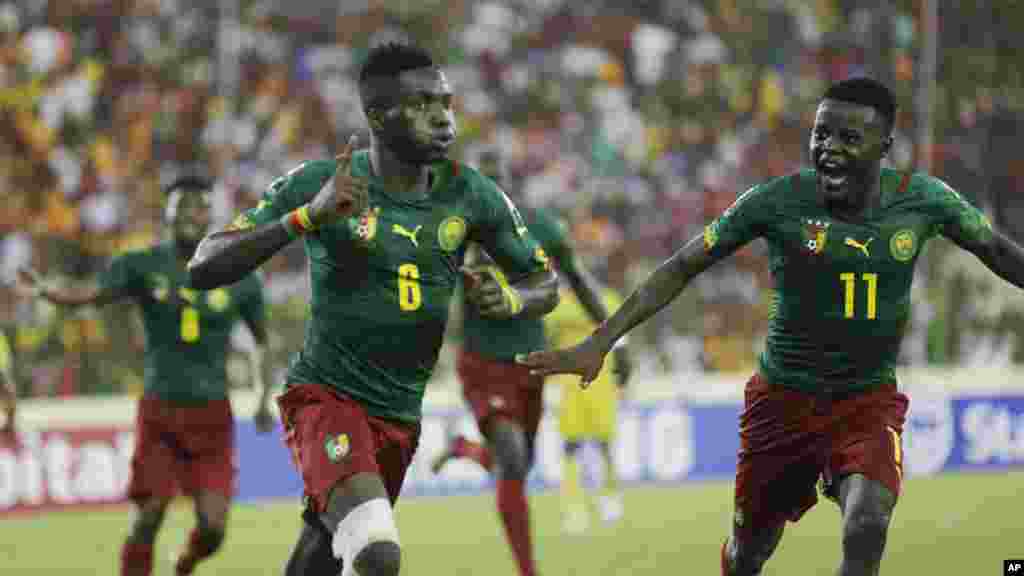 Ambroise Oyongo Bitolo du Cameroun, à gauche, célèbre après avoir marqué un but contre le Mali, lors du match de football du groupe D de la Coupe d'Afrique des Nations au satde de Malabo, Guinée équatoriale, mardi 20 janvier 2015.