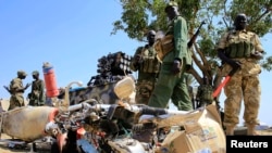 Tentara Sudan Selatan berdiri di dekat sepeda motor yang rusak dekat Bandara Bor, di baratlaut ibukota Juba, 25/12/2013.