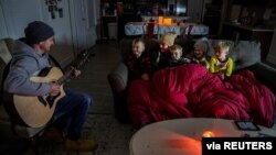 Brett Archibad, whose home was without electric power following winter weather, entertains his family as they try to stay warm in their home the BlackHawk neighborhood in Pflugerville, Texas, Feb. 16, 2021. (Ricardo B. Brazziell/via Reuters)