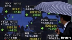 Papan elektronik memasang informasi indeks saham dari berbagai negara, di Tokyo, Jepang (6/7). 