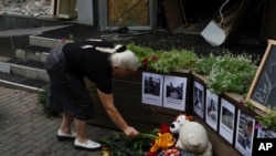 Una mujer local coloca flores en la exhibición conmemorativa en el restaurante RIA Pizzeria que fue atacado por un cohete ruso en Kramatorsk, región de Donetsk, Ucrania, el 29 de junio de 2023.