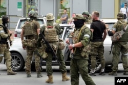 Members of Wagner group inspect a car in a street of Rostov-on-Don, on June 24, 2023.