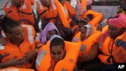 Des migrants secourus transportés un bateau en mer Méditerranée au large des côtes libyennes, le 4 octobre 2016