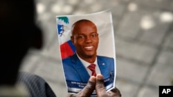 ARCHIVO - Una persona sostiene una fotografía del fallecido presidente haitiano Jovenel Moise durante su ceremonia conmemorativa en el Museo Nacional del Panteón en Puerto Príncipe, Haití, el 20 de julio de 2021.