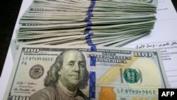 Pialang penukaran mata uang mempersiapkan transaksi mata gang US dolar, 1 Januari 2020. (Foto: AFP)
