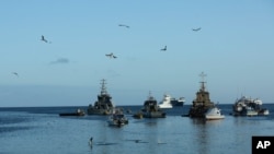 En esta foto del 2 de mayo de 2020, las aves vuelan sobre barcos de pesca y turísticos anclados en la bahía de San Cristóbal, Islas Galápagos, Ecuador.
