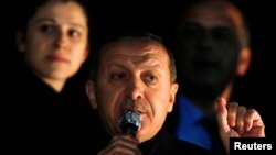 PM Turki Recep Tayyip Erdogan amemberikan sambutan di hadapan para pendukungnya setibanya di bandara Esenboga di Ankara (24/12).