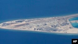 FILE - Chinese structures and an airstrip on the man-made Subi Reef at the Spratly group of islands in the South China Sea are seen from a Philippine Air Force C-130 transport plane of the Philippine Air Force, April 21, 2017.