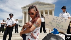 Manifestation devant la Cour suprême contre l'interdiction de l'avortement. Au premier plan, une jeune mère originaire du Maryland est venue avec sa fille de trois semaines, 21 mai 2019, Washington. 