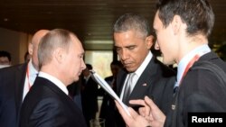 FILE - President Barack Obama, center, meets with Russian counterpart Vladimir Putin, left, during the Asia Pacific Economic Cooperation (APEC) summit in Beijing, Nov. 11, 2014. 