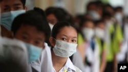 Students line up to sanitize their hands to avoid the contact of coronavirus before their morning class at a high school in Phnom Penh, Cambodia, Jan. 28, 2020. 