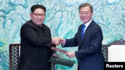 South Korean President Moon Jae-in and North Korean leader Kim Jong Un shake hands at the truce village of Panmunjom inside the demilitarized zone separating the two Koreas, South Korea, April 27, 2018.