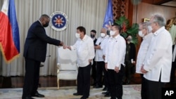 In this photo provided by the Malacanang Presidential Photographers Division, U.S. Secretary of Defense Lloyd Austin, left, does a fist bump with Philippine President Rodrigo Duterte at the Malacanang Palace in Manila, Philippines, July 29, 2021.