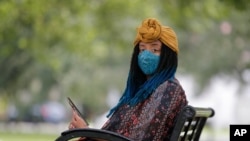 Jasmin Pierre poses for a photo with her smartphone app, in New Orleans, July 2, 2020. Pierre, who survived multiple suicide attempts, doesn't want people struggling alone. She created The Safe Place, a free Black-oriented mental health app.