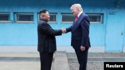 Arhiva - Predsednik SAD Donald Tramp rukuje se sa severnokorejskim liderom Kim Džong Unom, tokom sasanka u demilitarizovanoj zoni koja razdvaja dve Koreje, u Panmunjomu, Južna Koreja, 30. juna 2019.