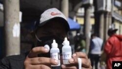 Un hombre muestra frascos de dióxido de cloro que compró en una farmacia de Cochabamba, Bolivia, para protegerse del coronavirus. Las autoridades rechazan su uso.