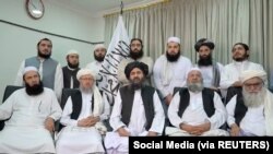Mullah Baradar Akhund, a senior official of the Taliban, seated with a group of men, makes a video statement, in this still image taken from a video recorded in an unidentified location and released on August 16, 2021. Social Media/via REUTERS 