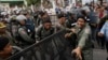 FILE - Police officers set up a roadblock on the outskirts of Phnom Penh, Cambodia, May 30, 2016, ahead of an opposition protest. Having dissolved the country's main opposition party, authorities are now moving against a human rights NGO.