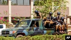 Des troupes circulent dans un véhicule près de l'ambassade de France dans le centre de Ouagadougou, au Burkina Faso, le vendredi 2 mars 2018. (AP Photo / Ludivine Laniepce)