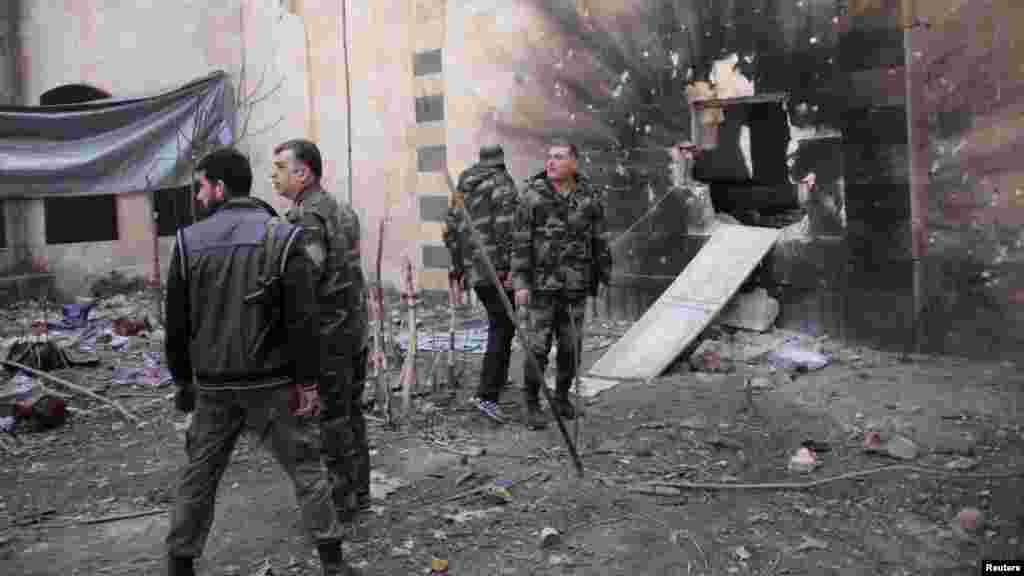 Forces loyal to Syria's President Bashar al-Assad walk in the old city of Aleppo, Feb. 11, 2014.