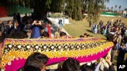 FILE - Relatives carry the body of journalist Malala Maiwand, who was shot and killed by gunmen soon after she left her house, during her funeral ceremony in Jalalabad, east of Kabul, Afghanistan, Dec. 10, 2020.