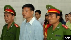 Blogger Truong Duy Nhat (C) stands trial at a local People's Court in the central city of Da Nang, March 4, 2014. 
