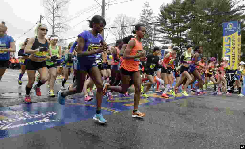 Runners cross the start line in the women's division of the Boston Marathon, in Hopkinton, April 20, 2015.